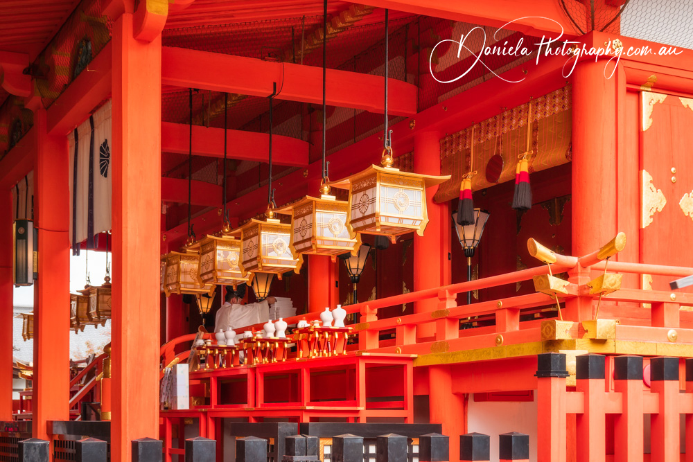 Architectural detail with golden lanterns at Fushimi Inari Shrine in Kyoto, Japan